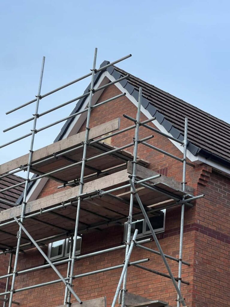 This is a photo of a roof which has just been repaired. There is a scaffold located at the gable end for access onto the roof. Works carried out by Lingfield Roofing Repairs