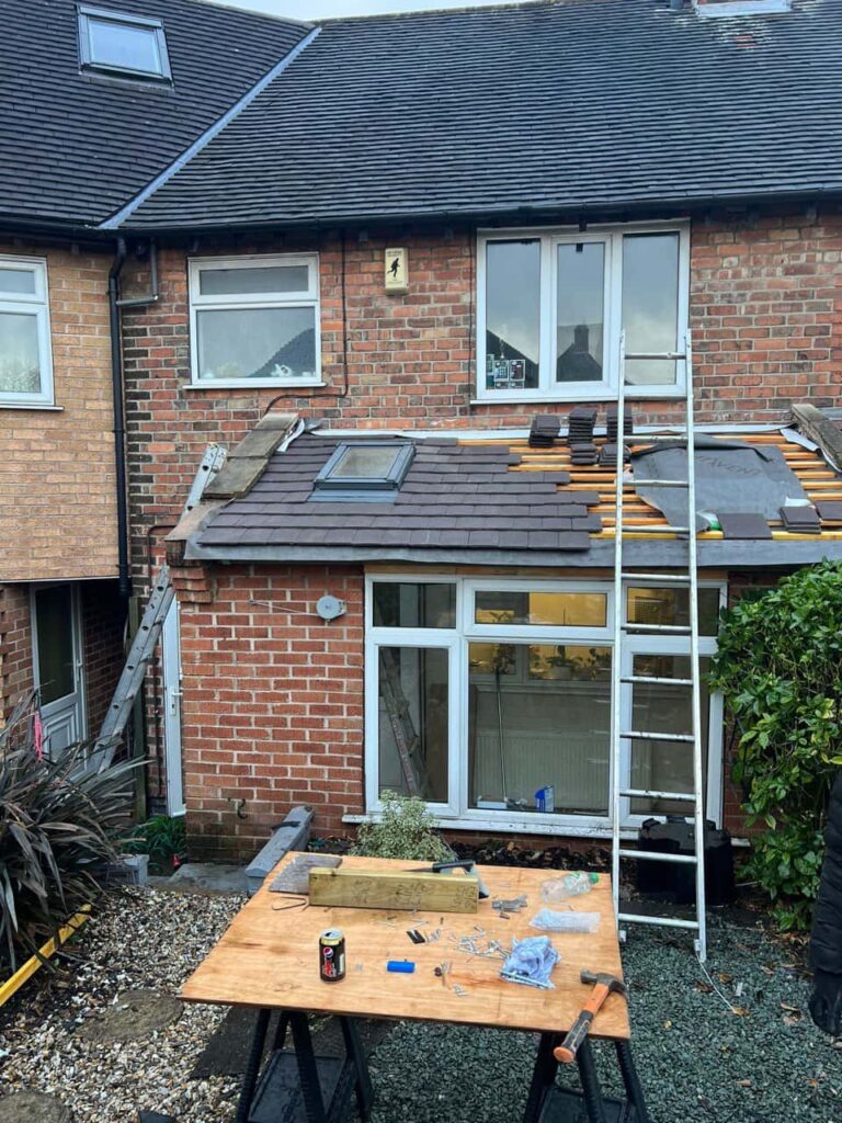 This is a photo of a roof extension that is having new roof tiles installed. This is a photo taken from the roof ridge looking down a tiled pitched roof on to a flat roof. Works carried out by Lingfield Roofing Repairs